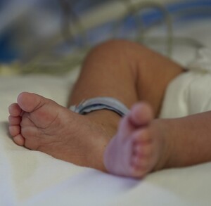 Pies de un bebé sobre una cama de hospital