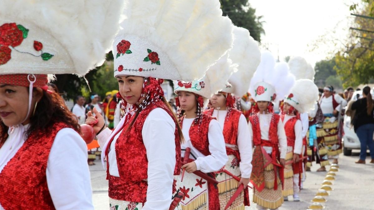 Grupo de mujeres con penacho en color blanco y atuendos de danzantes, en la peregrinación de Gómez Palacio