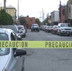 Hay carros estacionados y una cinta de precaución amarilla, además al fondo se encuentra una patrulla.