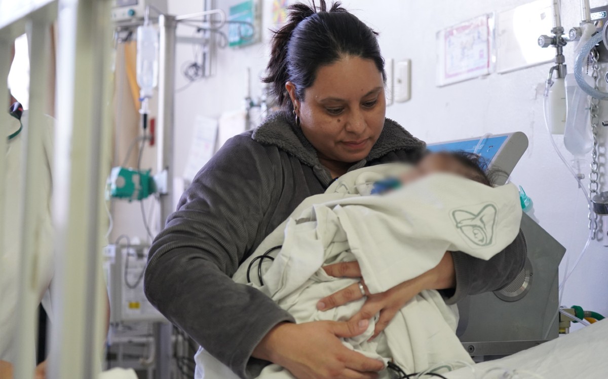 Madre sostiene en brazos a bebé