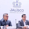 Tres funcionarios o políticos, sentados en una mesa, posan en una conferencia de prensa en Jalisco bajo el logo del 