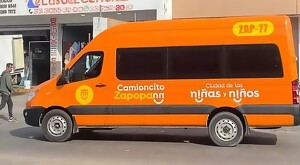 Unidad tipo van de Mi Camioncito color naranja vista de lado con los logotipos del Gobierno de Zapopan