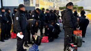 Hombres vestidos con uniforme policial, formados de costado.