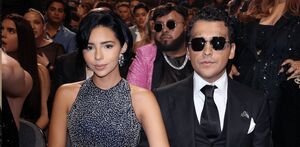Ángela Aguilar y Christian Nodal juntos en una entrega de premios. Ángela luciendo un vestido negro con diamantes en plateado y Nodal con lentes oscuros.