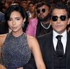 Ángela Aguilar y Christian Nodal juntos en una entrega de premios. Ángela luciendo un vestido negro con diamantes en plateado y Nodal con lentes oscuros.