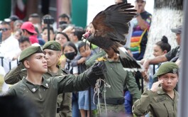 Águila sobre cadete uniformado y personas de fondo