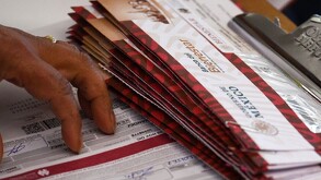 Mano fr una mujer sosteniendo sobres blancos que contienen tarjetas