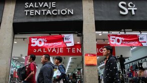 personas caminan afuera de una tienda en puebla con promociones del buen fin