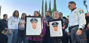 Familiares y colegas de policías de Jalisco rinden homenaje. Mujeres en el centro sostienen dos retratos de oficiales de policía caídas en un ambiente de triste