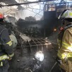 Elementos de Protección Civil y Bomberos de Jalisco en la bodega donde abandonada con múltiples objetos calcinados y escombro alrededor