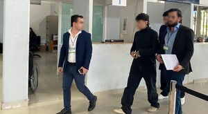 Junior H acompañado de sus abogados, todos con la cara censurada, caminando en las oficinas de la Fiscalía de Jalisco