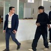 Junior H acompañado de sus abogados, todos con la cara censurada, caminando en las oficinas de la Fiscalía de Jalisco