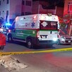 Ambulancia de la Cruz Verde de Guadalajara y patrullas de la Policía de Guadalajara dentro del área acordonada de noche con autos y casas alrededor