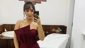 Joven mujer con vestido color guinda sosteniendo un celular