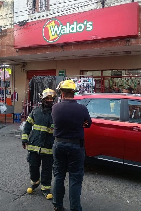 Bomberos platicando afuera de una tienda Waldo's en Veracruz.