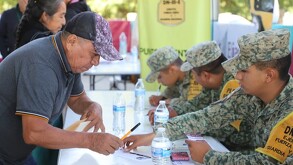 Señor de edad adulta firma recibo de apoyos para reconstruir su patrimonio en Sierra Norte de Puebla.