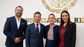 Pablo Lemus y otro hombre en traje posan junto a la política Claudia Sheinbaum y una mujer, todos sonriendo bajo el Escudo Nacional. Se sugiere una reunión