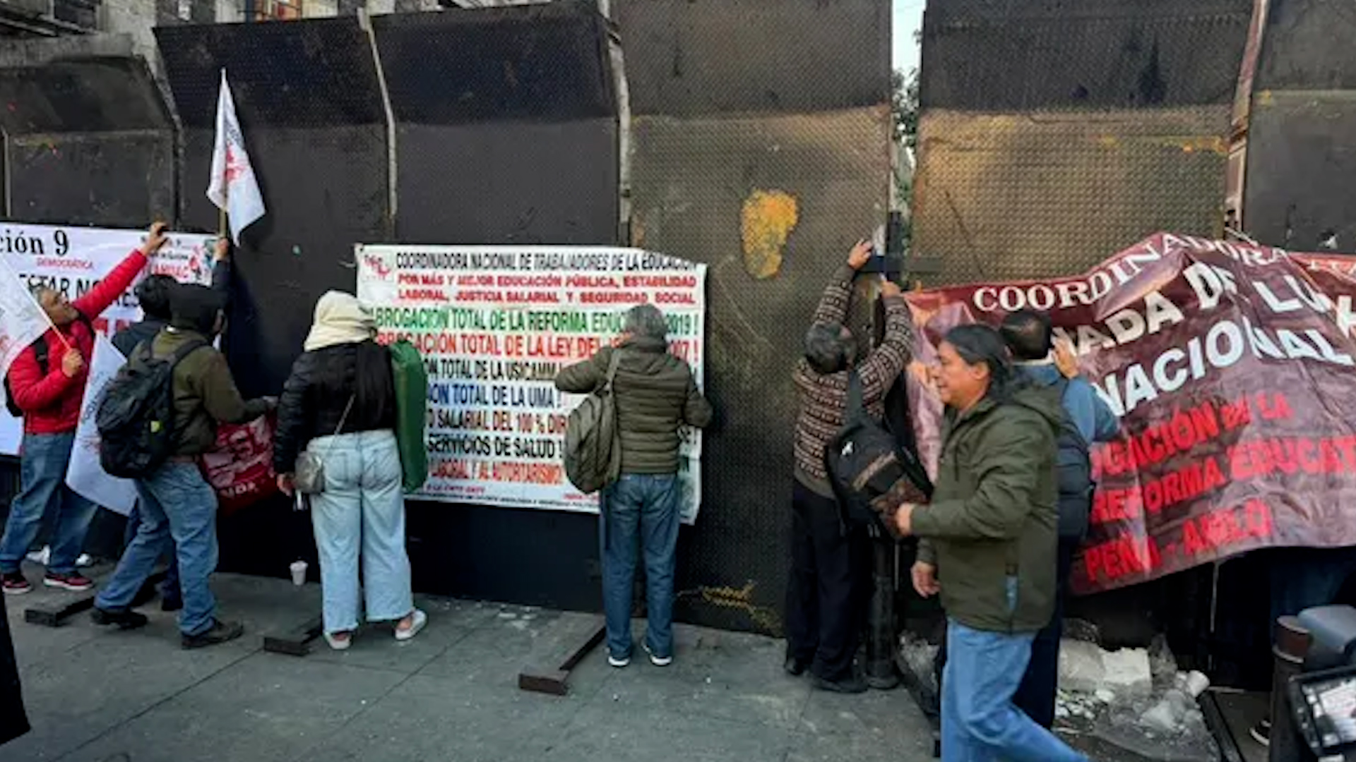 Maestros de la CNTE intentan derribar valla para dialogar con la presidenta.