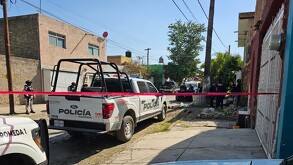 Miembros de un colectivo de búsqueda excavan en un terreno baldío. Una mujer lleva una playera con el rostro de una persona desaparecida