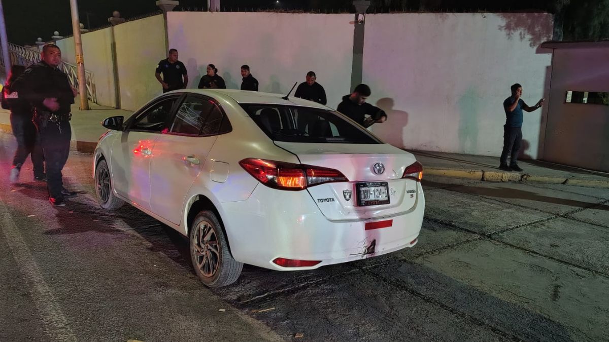 carro blanco afectado por un choque de una motocileta.
