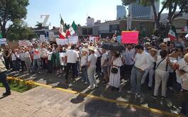 Grupo de personas reunidas, algunos con carteles