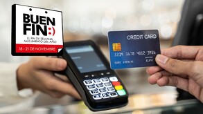 Persona sosteniendo una tarjeta de crédito azul frente a una terminal bancaria siendo sostenida por otra persona