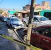 Patrulla de la Policía de Tlaquepaque estacionada fuera de la casa donde fue asesinada la joven con autos alrededor y una cinta policiaca puesta.