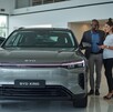 una pareja viendo un auto byd king en una agencia