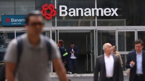 Personas caminando frente a un banco en la Ciudad de México.