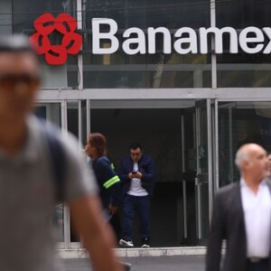 Personas caminando frente a un banco en la Ciudad de México.