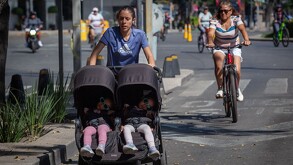 Mujer paseando a sus bebés en calles de la Ciudad de México.