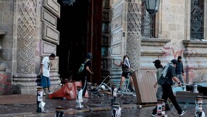 Manifestantes encapuchados afuera del Palacio de Gobierno en Guadalajara con diversos objetos materiales destrozados por el suelo