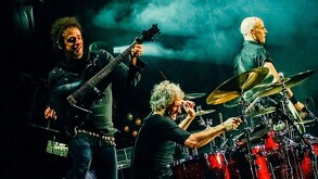 Gustavo Cerati, Charly Alberti y Zeta Bosio miembros de Soda Stereo tocando instrumentos en concierto