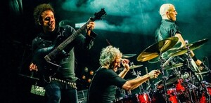 Gustavo Cerati, Charly Alberti y Zeta Bosio miembros de Soda Stereo tocando instrumentos en concierto
