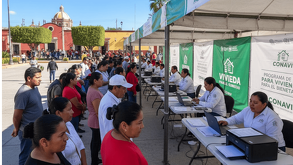 Un módulo de registro del Programa de Vivienda para el Bienestar en México, con personas haciendo fila para registrarse, personal de Conavi atendiendo en mesas