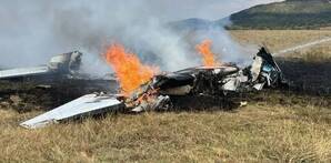 Avioneta incendiándose y bombero apagándola con manguera