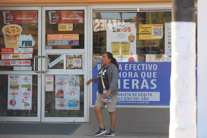 Mujer saliendo de una tienda Oxxo.
