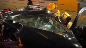 Bomberos se encuentran auxiliando en un accidente donde está involucrado un automóvil con los vidrios estrellados.