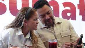 Diputados Andrés Villegas y Olga Romero viendo un celular en el zócalo de Puebla.