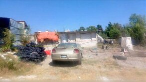 autos afuera de una casa donde ocurrió un feminicidio en los reyes de juárez