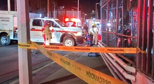 Ambulancia de la Cruz Roja y elementos de Protección Civil y Bomberos de Zapopan detrás de una cinta policiaca que acordona el exterior de la obra abandonada