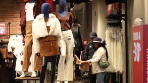 una pareja revisa ofertas en una tienda de ropa durante el buen fin