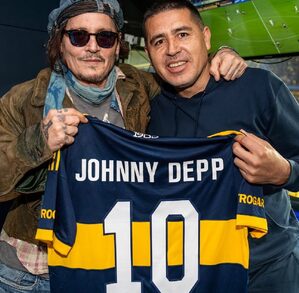 Juan Román Riquelme posando para una fotografía en un palco de 'La Bombonera' junto a Johnny Depp y una camiseta de Boca Juniors.