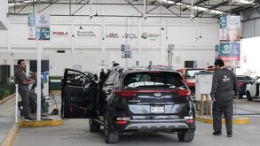 trabajadores realizan la verificación vehicular en un verificentro de puebla