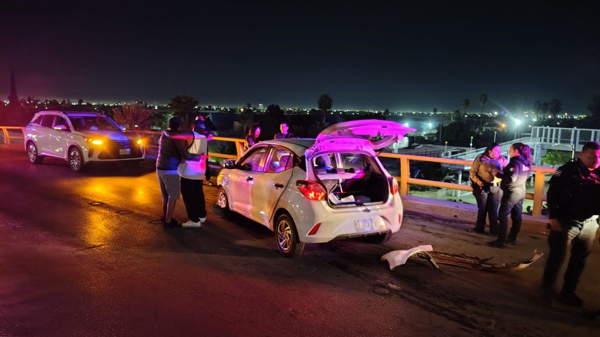 Imágenes de choque entre dos vehículos en puente de Torreón durante la madrugada, personas abrazándose.