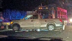 Camioneta siendo embestida por un tráiler en una carretera, de noche.