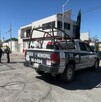 En la calle se ve una patrulla de la policía municipal, tres policías y una cinta amarilla de precaución.