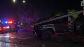 Hay una camioneta gris que acaba de chocar y una luminaria caída.