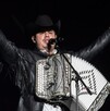 Alfredo Olivas, cantante de regional mexicano,  en concierto tocando el acordeón