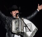 Alfredo Olivas, cantante de regional mexicano,  en concierto tocando el acordeón